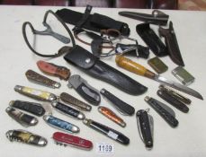 A collection of assorted penknives, pocket knives, lighters and catapults including Marbles, Soker,