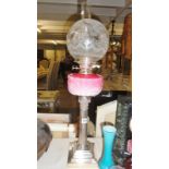 A Victorian silver plated peg oil lamp with pink glass font.