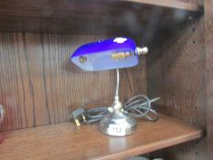 A small bankers lamp with blue glass shade.