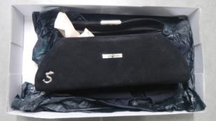 A boxed black rectangular Strutt handbag with silver coloured handle.