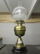 A brass oil lamp with pot base, drop in font and complete with shade and chimney.