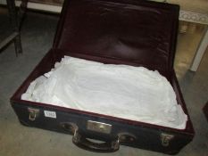 A vintage suitcase of good linen including table cloths, 4 Edwardian night gowns etc.