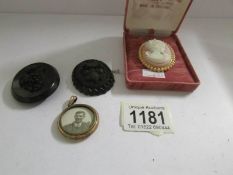 A photo locket, a cameo brooch and 2 Whitby jet brooches (missing pins).