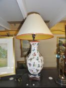 A pottery table lamp decorated with butterflies and complete with shade.