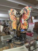 An art nouveau style figurine table lamp with Tiffany style leaded glass wings.