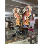 An art nouveau style figurine table lamp with Tiffany style leaded glass wings.