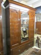 A mahogany inlaid wardrobe with mirror door.