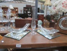 2 unusual glass items on mirrored trays and a glass vase.