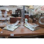 2 unusual glass items on mirrored trays and a glass vase.