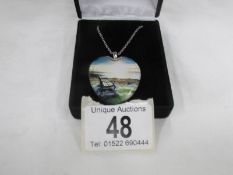 A Danbury Mint white metal pendant with seashore scene and poem on reverse of pendant.