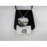 A Danbury Mint white metal pendant with seashore scene and poem on reverse of pendant.