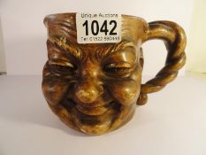 An unusual 19th century pottery face mug with rope handle,