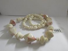 A long necklace of prismatic shaped beads interspaced with other beads.