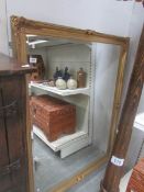 A large gilt framed bevel edged mirror.