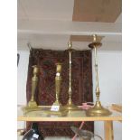 A pair of tall brass candlesticks and one other pair.