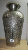 A large embossed metal vase.