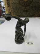A bronze figure of a discus thrower.