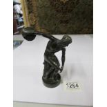 A bronze figure of a discus thrower.