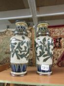 A pair of Doulton Lambeth Frank Butler stoneware leaf pattern vases a/f (one repaired and one with