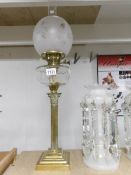 A brass Corinthian column oil lamp with glass font, shade and chimney.