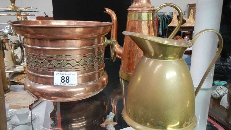 A copper planter, copper coffee pot and a brass jug.