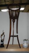 A mahogany basket shaped plant stand.