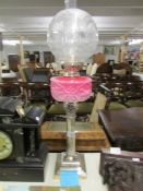 A silver plate Corinthian column oil lamp with shade and chimney.