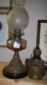 An oil lamp with glass font and a brass oil lamp font.