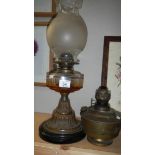 An oil lamp with glass font and a brass oil lamp font.