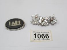 A black Wedgwood brooch in a silver mount together with a mother of pearl brooch set with cultured