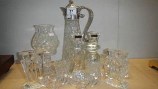 A glass claret jug, a glass candle lamp, a pair of candlesticks and a pair of salts.