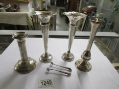 A pair of silver spill vases, one other, a silver candlestick and a pair of silver sugar tongs.