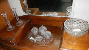 A glass trinket set, a pair of glass candlesticks and a glass bowl.