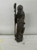 An early-mid 20th century wooden figure of an oriental wise man.