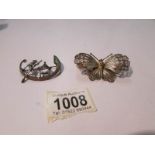 A filigree butterfly brooch marked 800 and a white metal brooch with Chinese figure in boat.