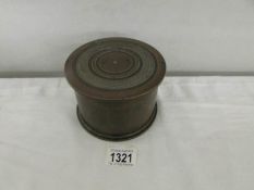 A heavy brass lidded box made from a shell case.