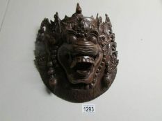 An early 20th century carved hard wood wall mask.