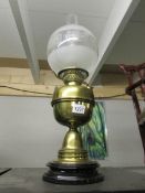 A brass oil lamp on pot base complete with chimney and later shade.