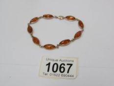 A 9ct gold bracelet with amber ovals mounted in gold.