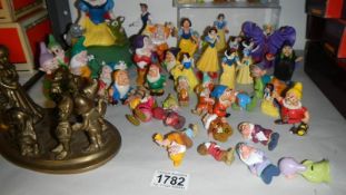 A collection of Disney Snow White and the Seven Dwarfs figures including plastic,