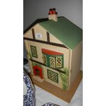 A 1950's dolls house with furniture.