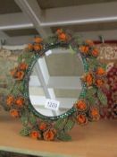 An oval dressing table mirror with beaded frame.