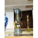 A glass claret jug with pewter top and base.