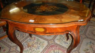 A marquetry inlaid centre table with drawer and protective glass top.