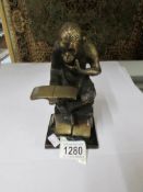 A bronze? figure of a chimpanzee reading.