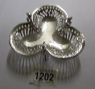 A silver dish in the shape of a clover leaf.
