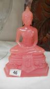 A pink Buddha figure.