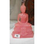 A pink Buddha figure.