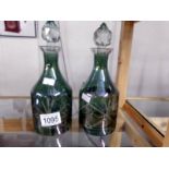 A pair of green cut glass decanters.
