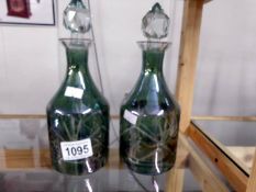 A pair of green cut glass decanters.
